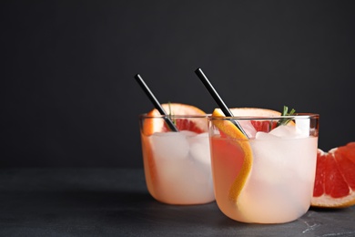 Photo of Glasses of cocktail and grapefruit slice on table. Space for text
