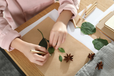 Little girl working with natural materials at table, closeup. Creative hobby