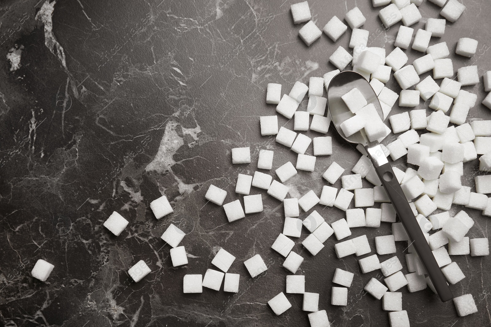 Photo of Refined sugar cubes on dark grey background, top view