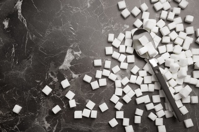 Photo of Refined sugar cubes on dark grey background, top view