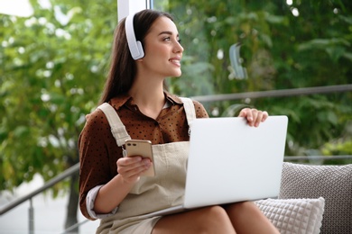 Young woman working with laptop near window at home office