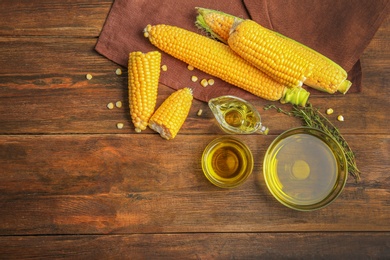 Flat lay composition with fresh corn oil on wooden table