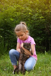 Cute little girl with cat in green park