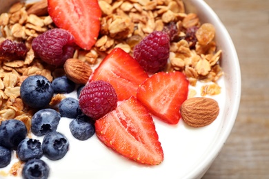 Tasty homemade granola served on wooden table, closeup. Healthy breakfast