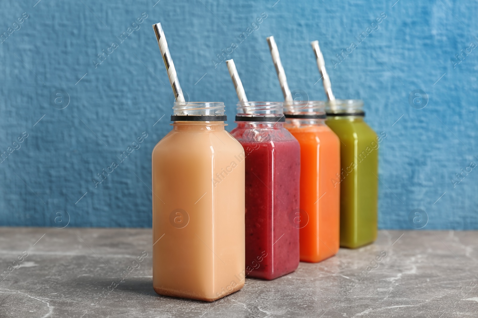 Photo of Bottles with healthy detox smoothies on table