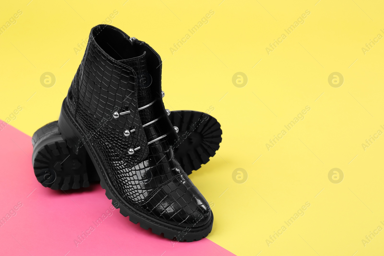 Photo of Pair of stylish ankle boots on color background. Space for text