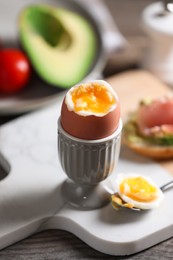 Soft boiled chicken egg served on wooden table