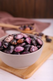 Photo of Bowl with dry kidney beans on white table