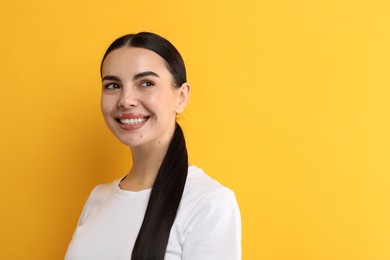 Photo of Beautiful woman with clean teeth smiling on yellow background, space for text