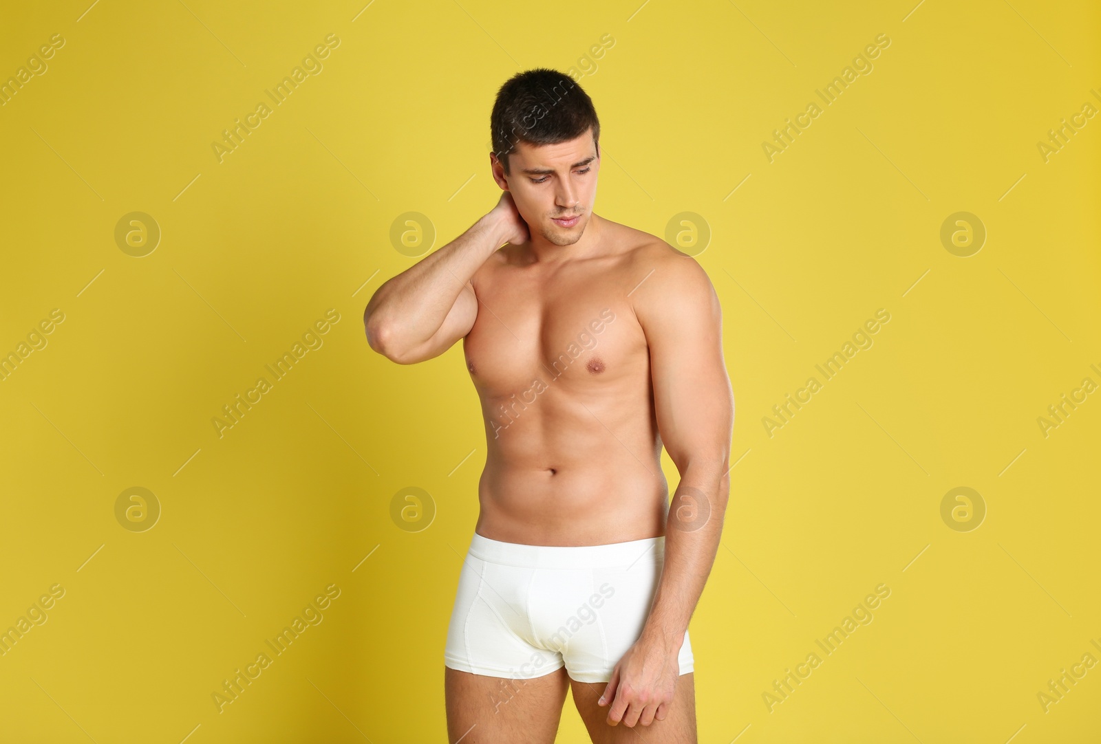 Photo of Man with sexy body on yellow background