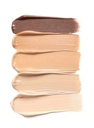 Photo of Samples of skin foundation on white background, top view