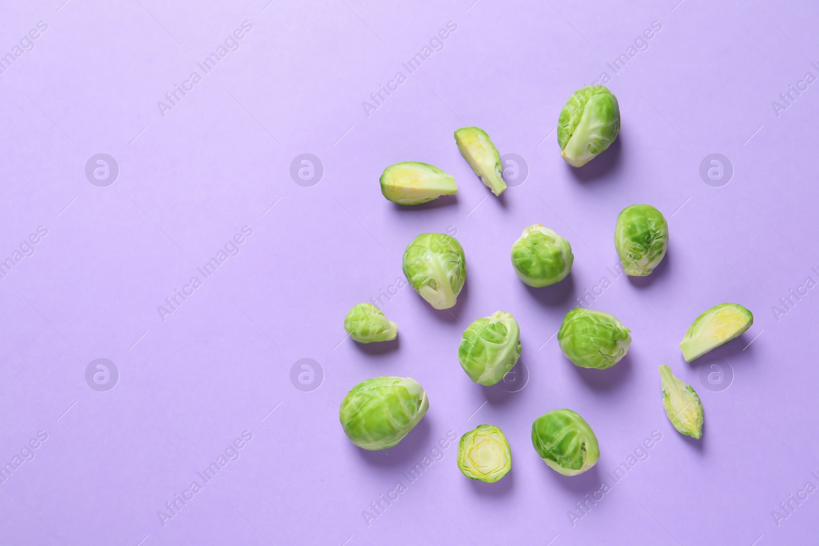 Photo of Fresh Brussels sprouts on color background, flat lay. Space for text