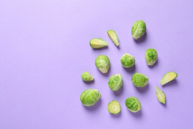 Photo of Fresh Brussels sprouts on color background, flat lay. Space for text