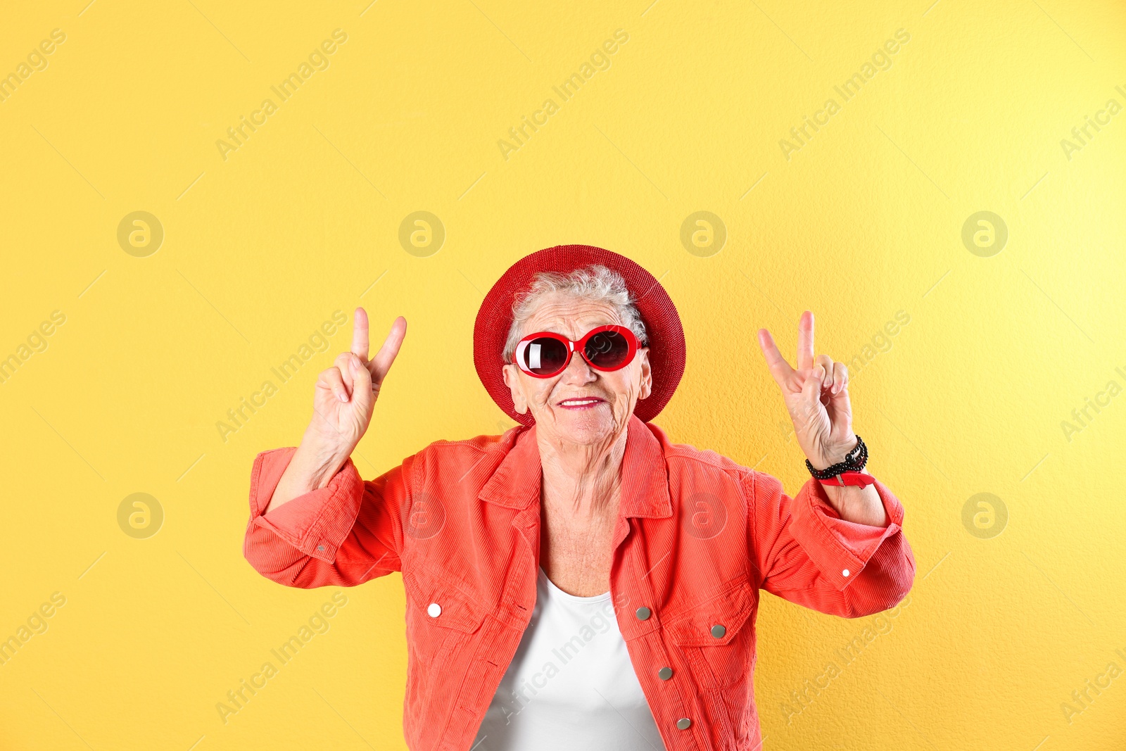 Photo of Portrait of cool grandmother on color background