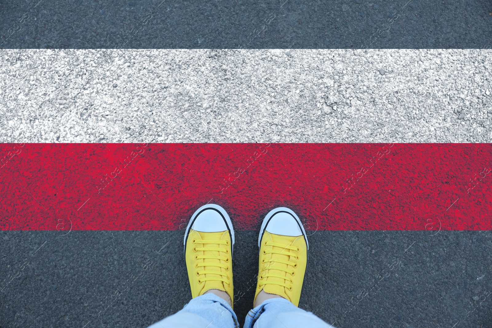 Image of Immigration. Woman standing on asphalt near flag of Poland, top view