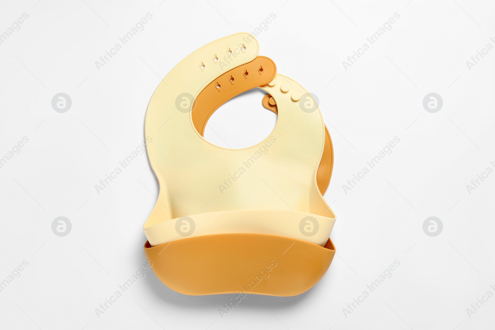 Photo of Color silicone baby bibs isolated on white, top view