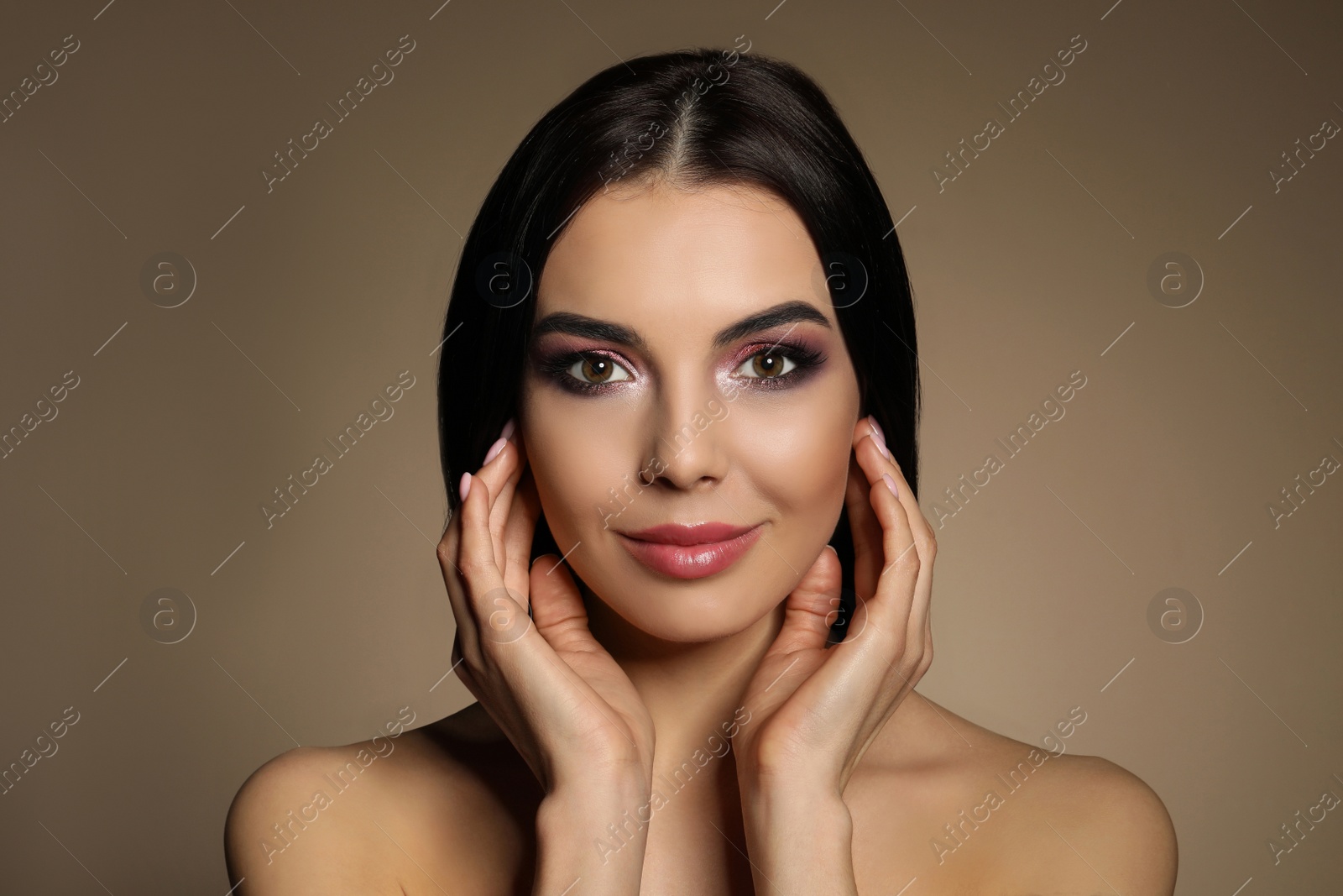 Photo of Beautiful young woman with evening makeup on brown background. Eye shadow product