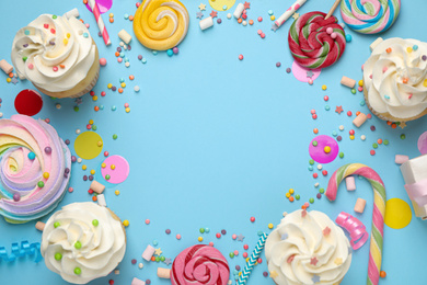 Photo of Flat lay composition with cupcakes on light blue background, space for text. Birthday party