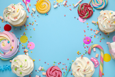 Flat lay composition with cupcakes on light blue background, space for text. Birthday party