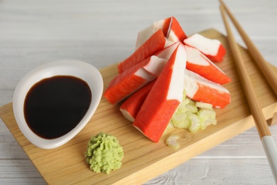 Photo of Cut crab sticks served on wooden table, closeup