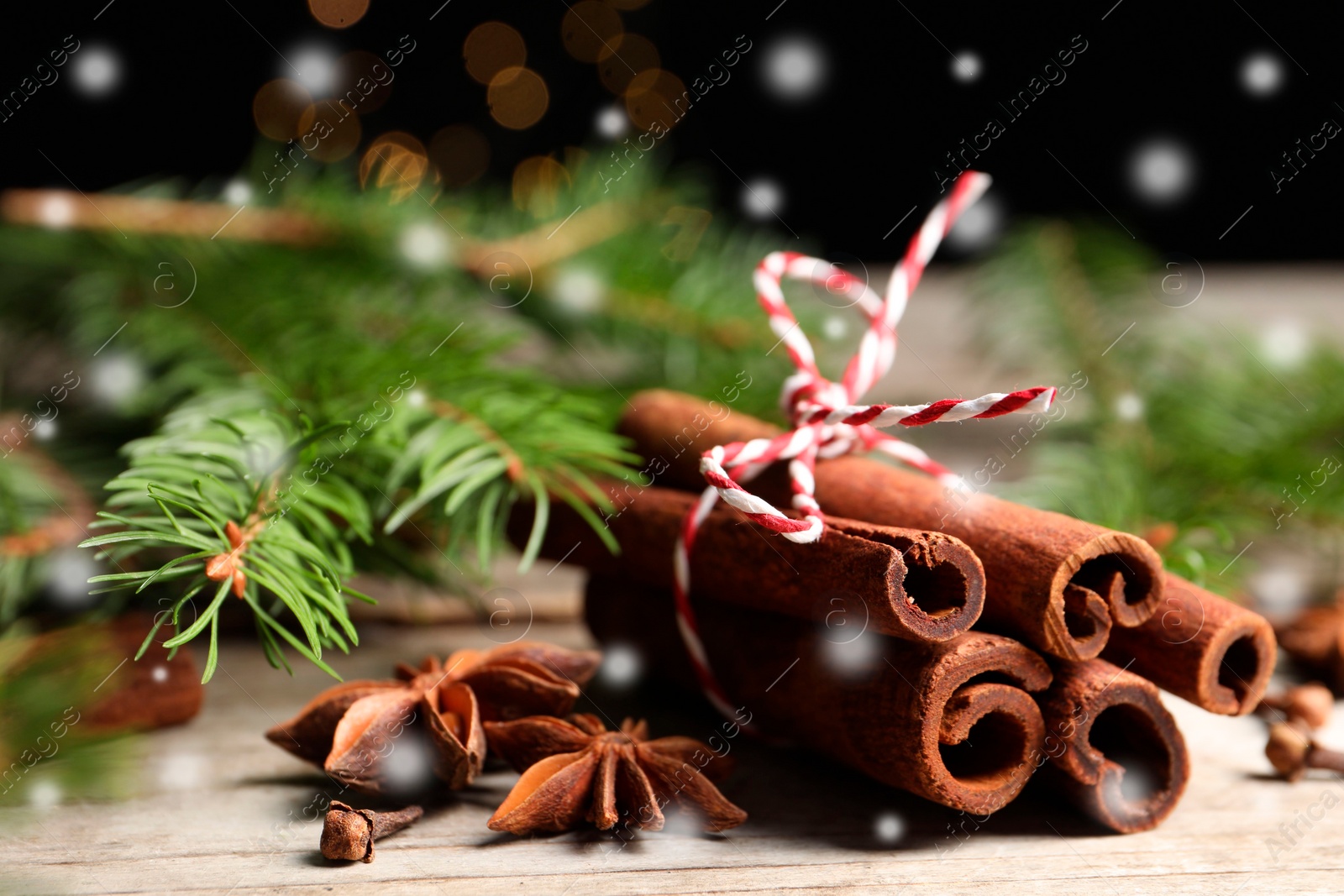 Image of Different spices and fir tree branches on white wooden table, closeup. Cinnamon, anise, cloves