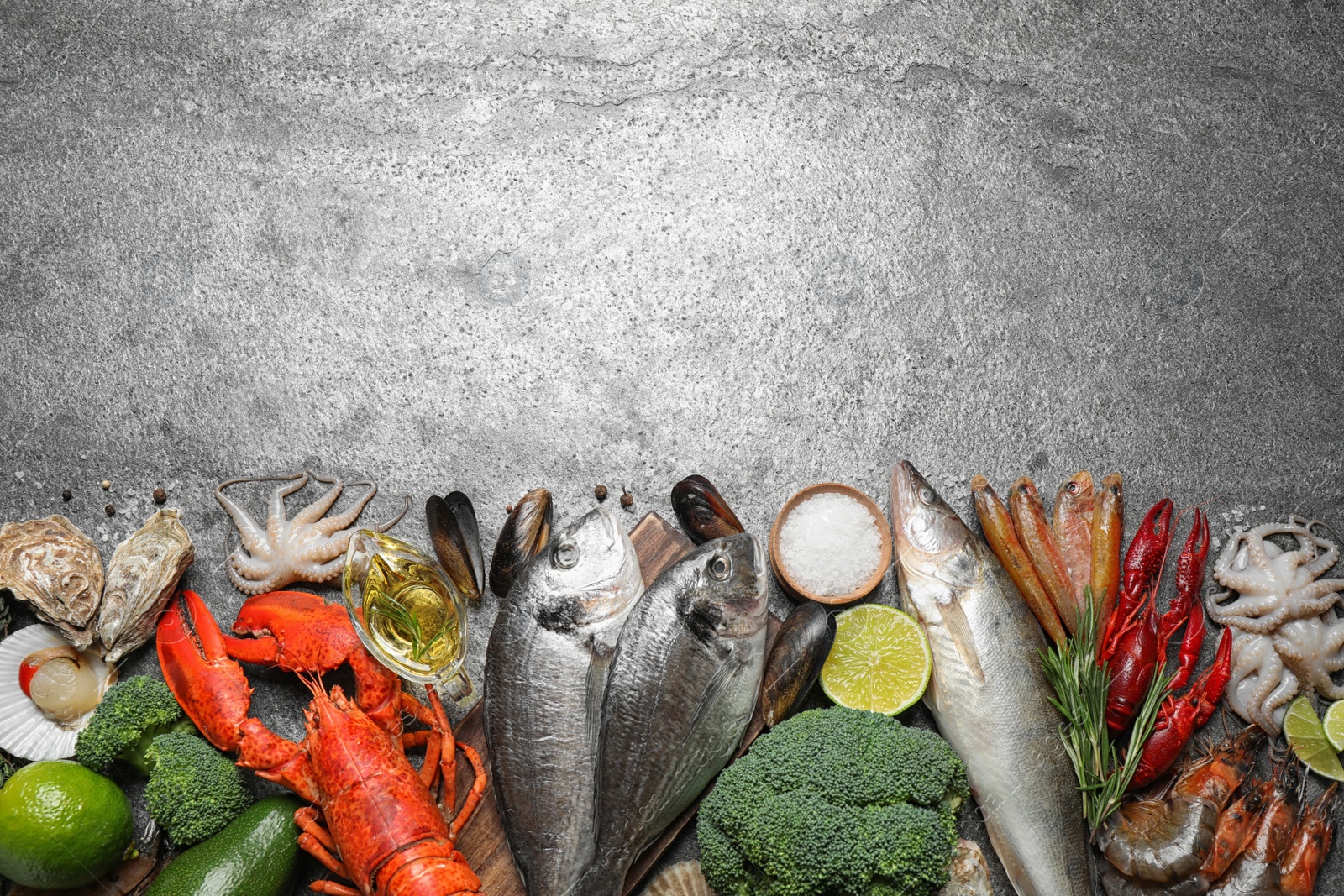 Photo of Fresh fish and different seafood on grey table, flat lay. Space for text