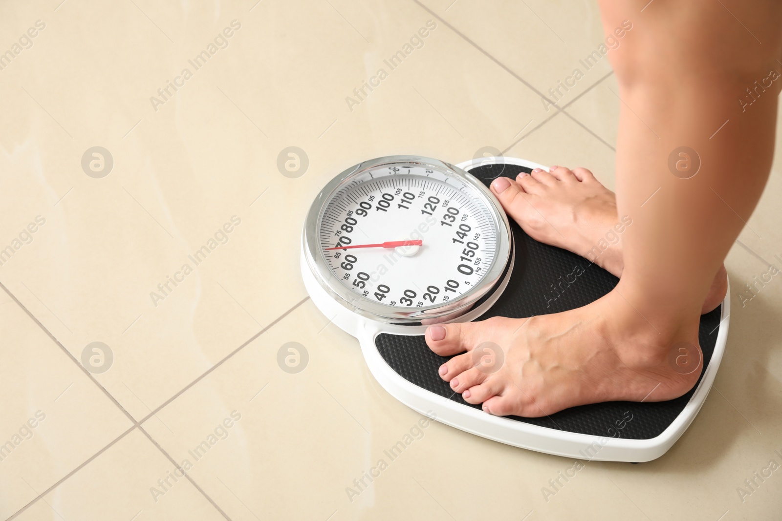 Photo of Woman standing on scales indoors, space for text. Overweight problem