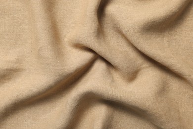 Texture of beige crumpled fabric as background, top view