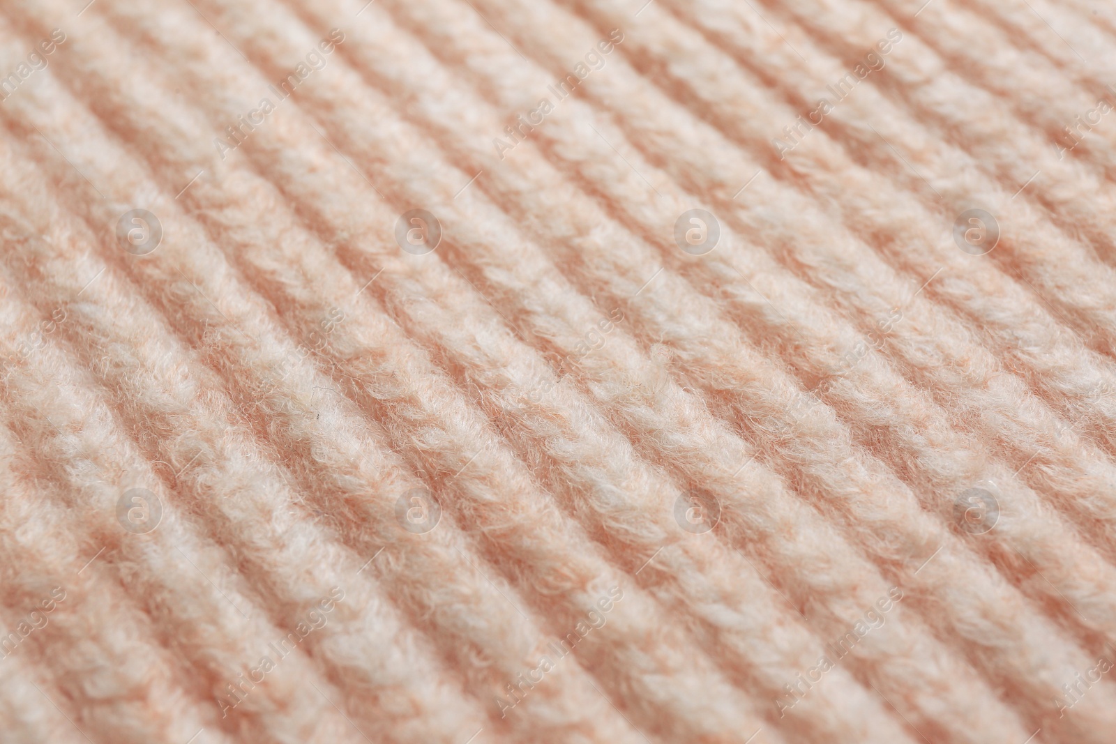 Photo of Beautiful pale pink knitted fabric as background, closeup