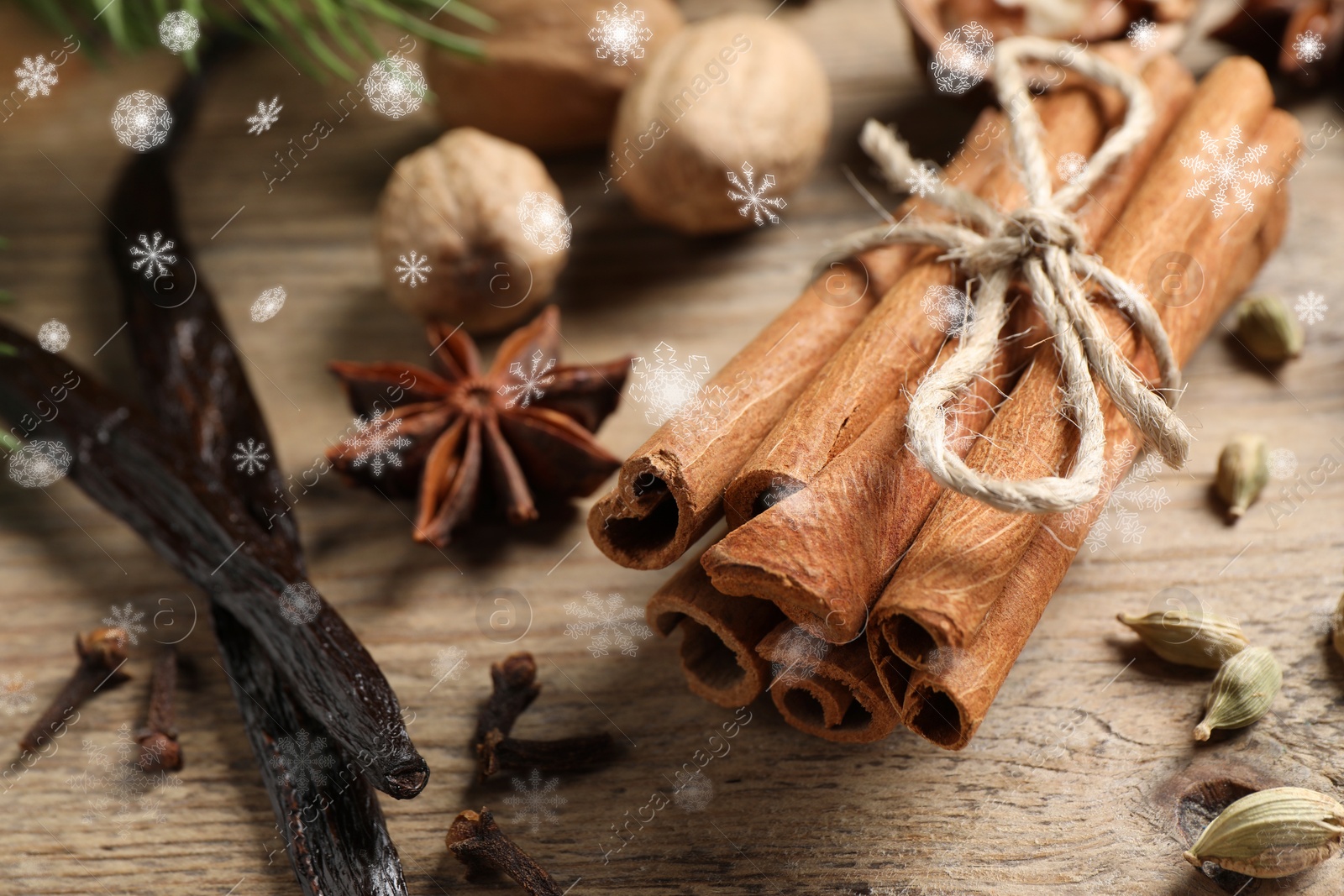 Image of Different spices on wooden table, closeup. Cinnamon, cloves, anise, cardamom, vanilla, nutmegs