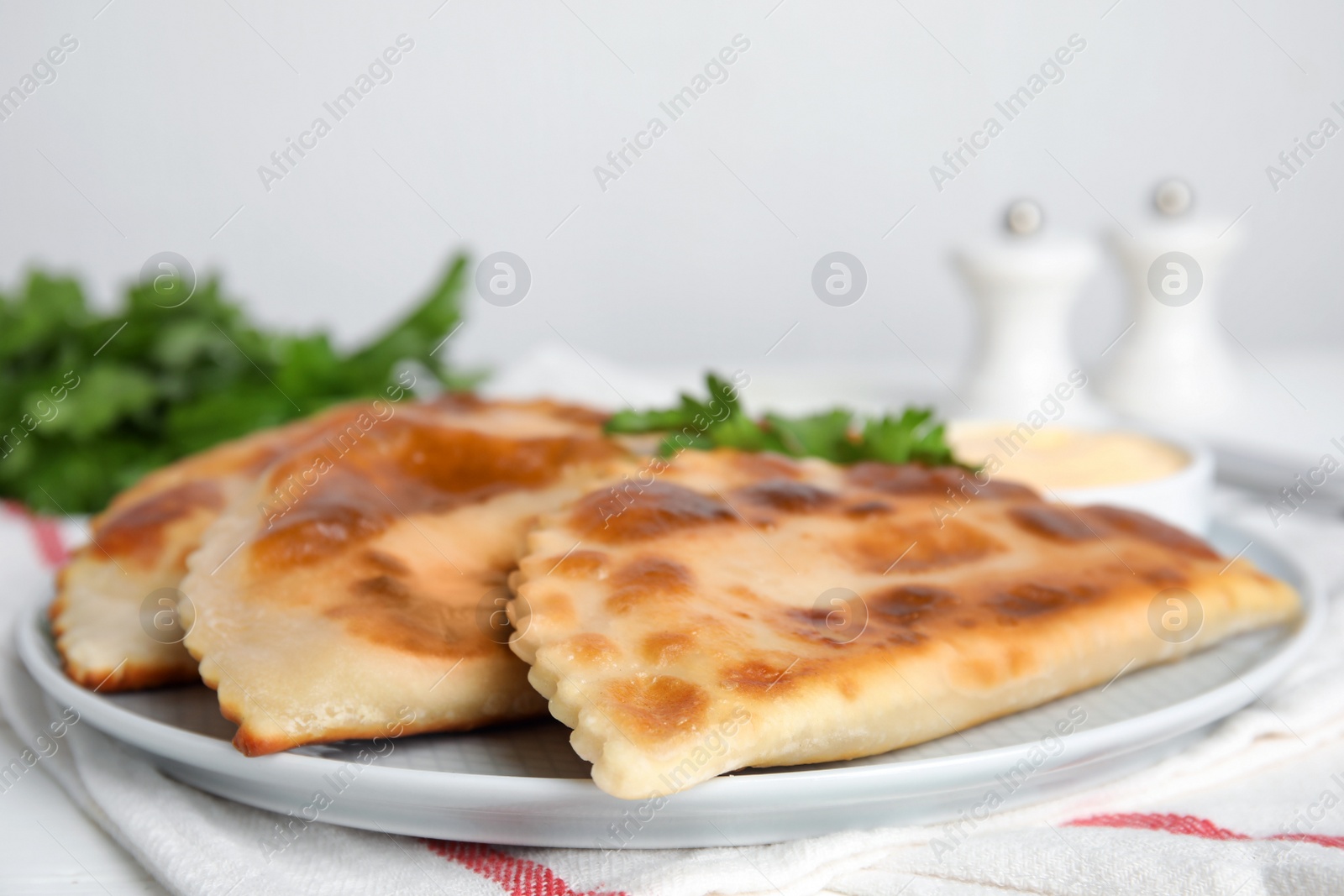Photo of Plate with delicious fried chebureki on table