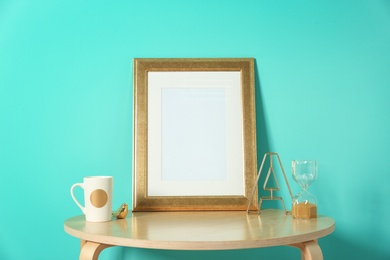 Mockup of blank frame and hourglass on table