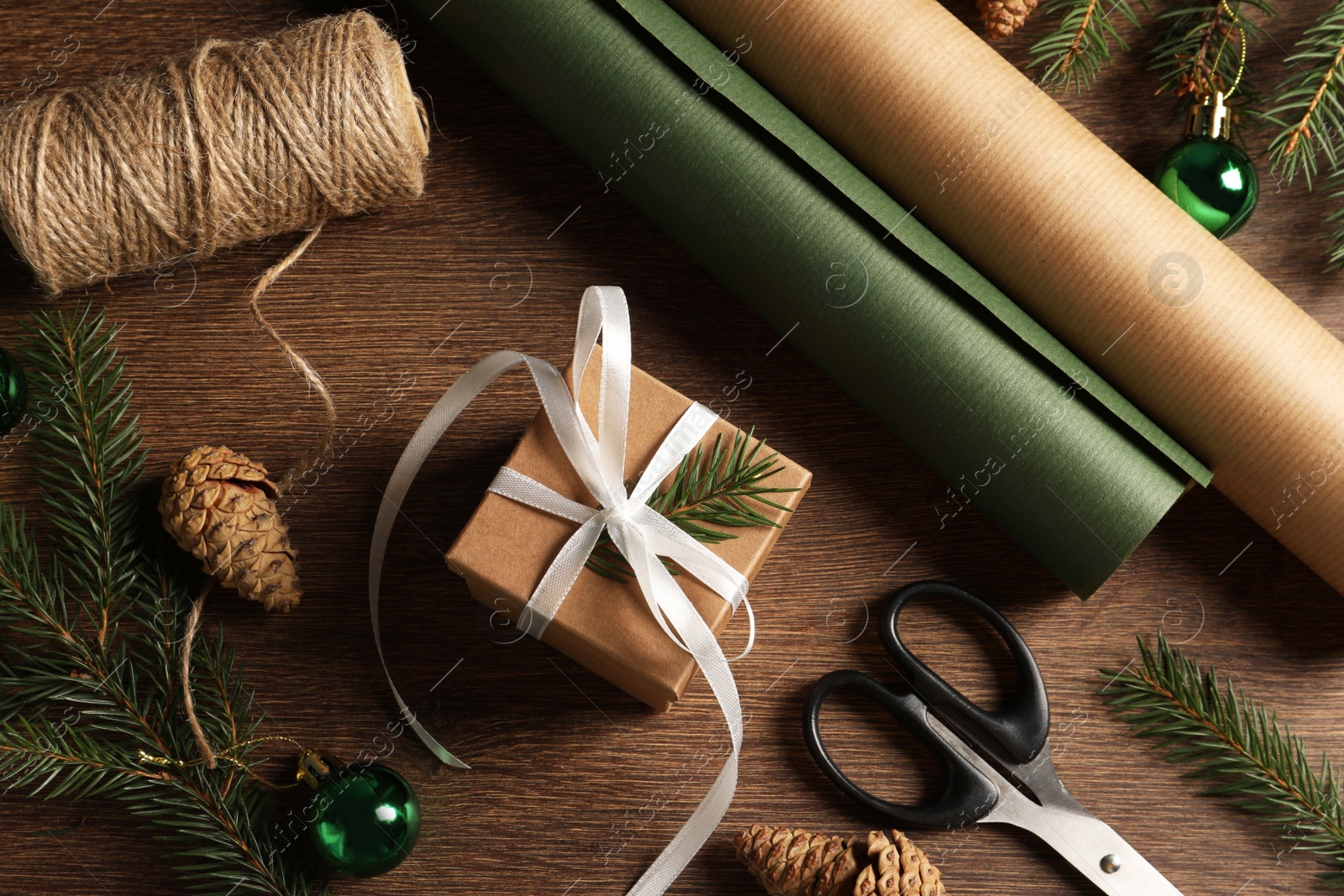 Photo of Flat lay composition with beautiful gift box and decorations on wooden table. Christmas present