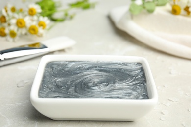 Professional face mask on light gray marble table, closeup
