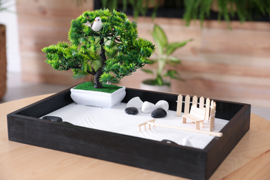 Beautiful miniature zen garden on wooden table indoors