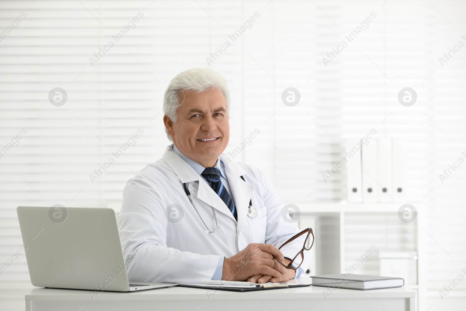 Photo of Portrait of senior doctor in white coat at workplace