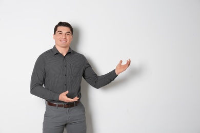 Photo of Portrait of young man in stylish outfit on light background