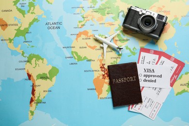 Photo of Flat lay composition with passport and tickets on world map. Space for text