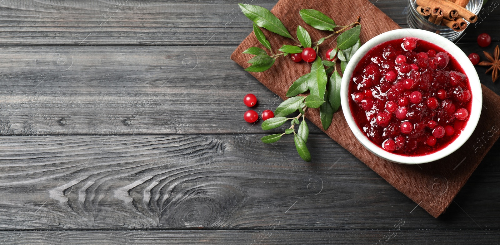 Image of Flat lay composition with cranberry sauce on grey wooden table, space for text. Banner design