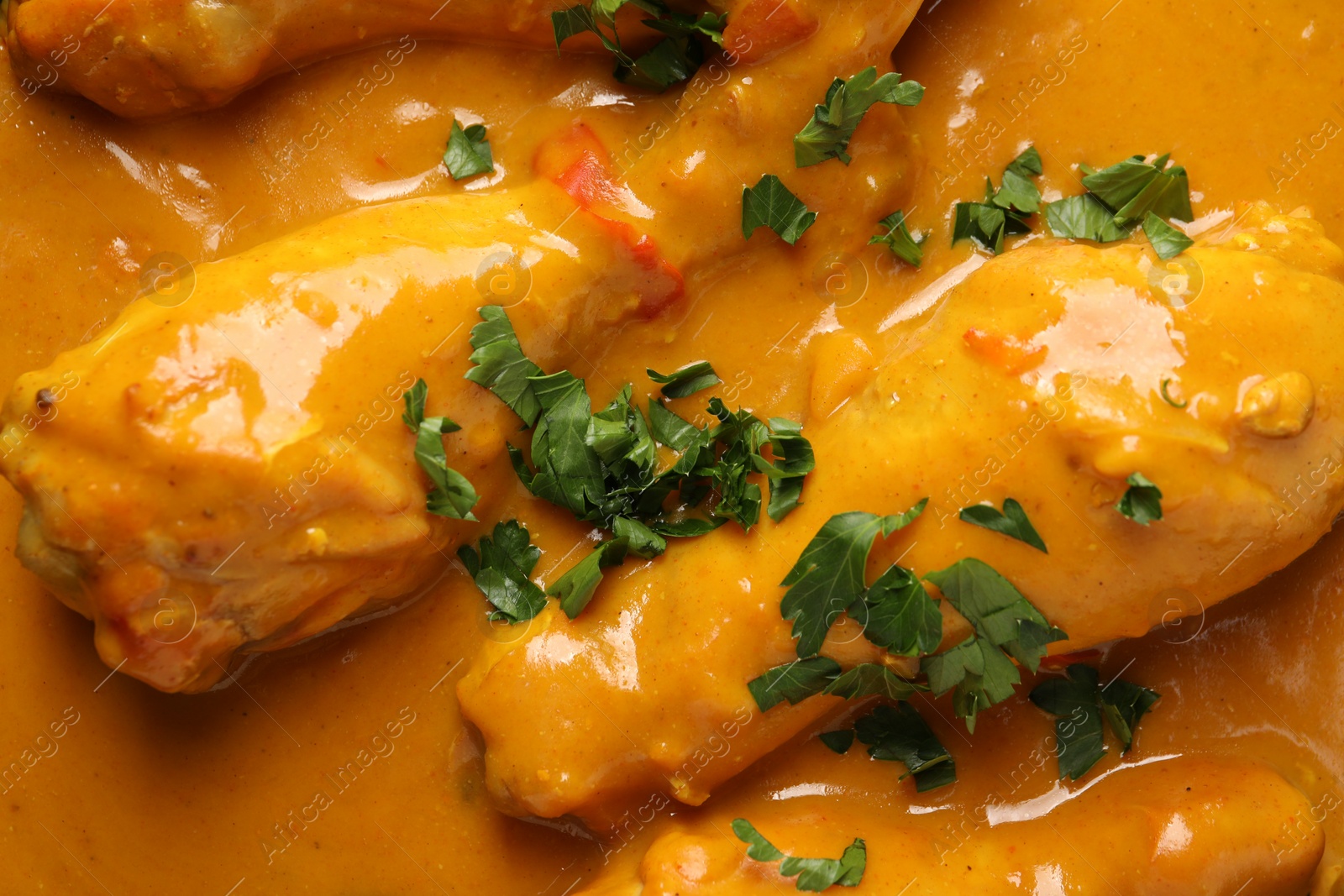 Photo of Tasty chicken curry with parsley as background, top view