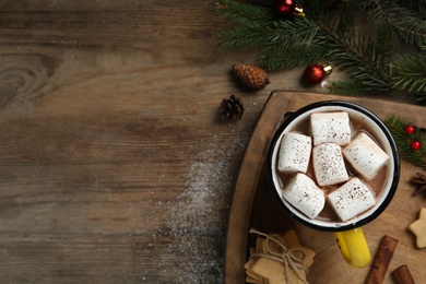 Photo of Flat lay composition with delicious marshmallow cocoa and Christmas decor on wooden table. Space for text
