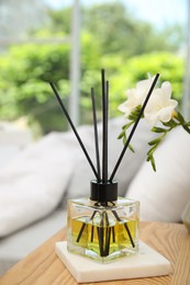 Reed diffuser on wooden nightstand in bedroom