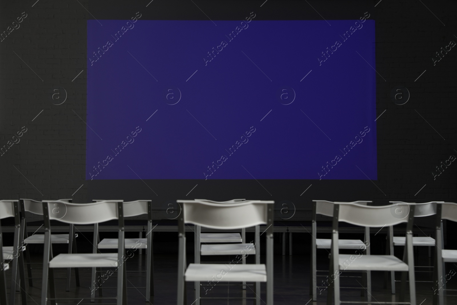 Photo of Empty conference room with projection screen and chairs