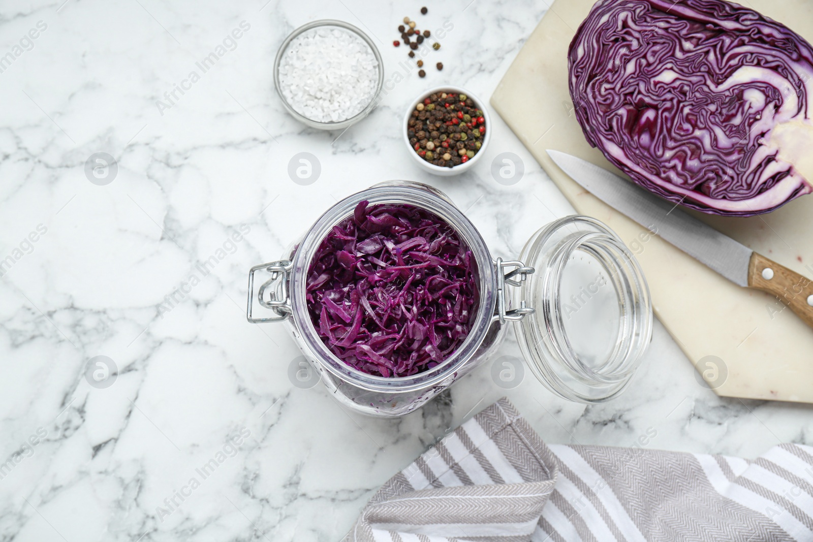 Photo of Tasty red cabbage sauerkraut and different ingredients on white marble table, flat lay. Space for text