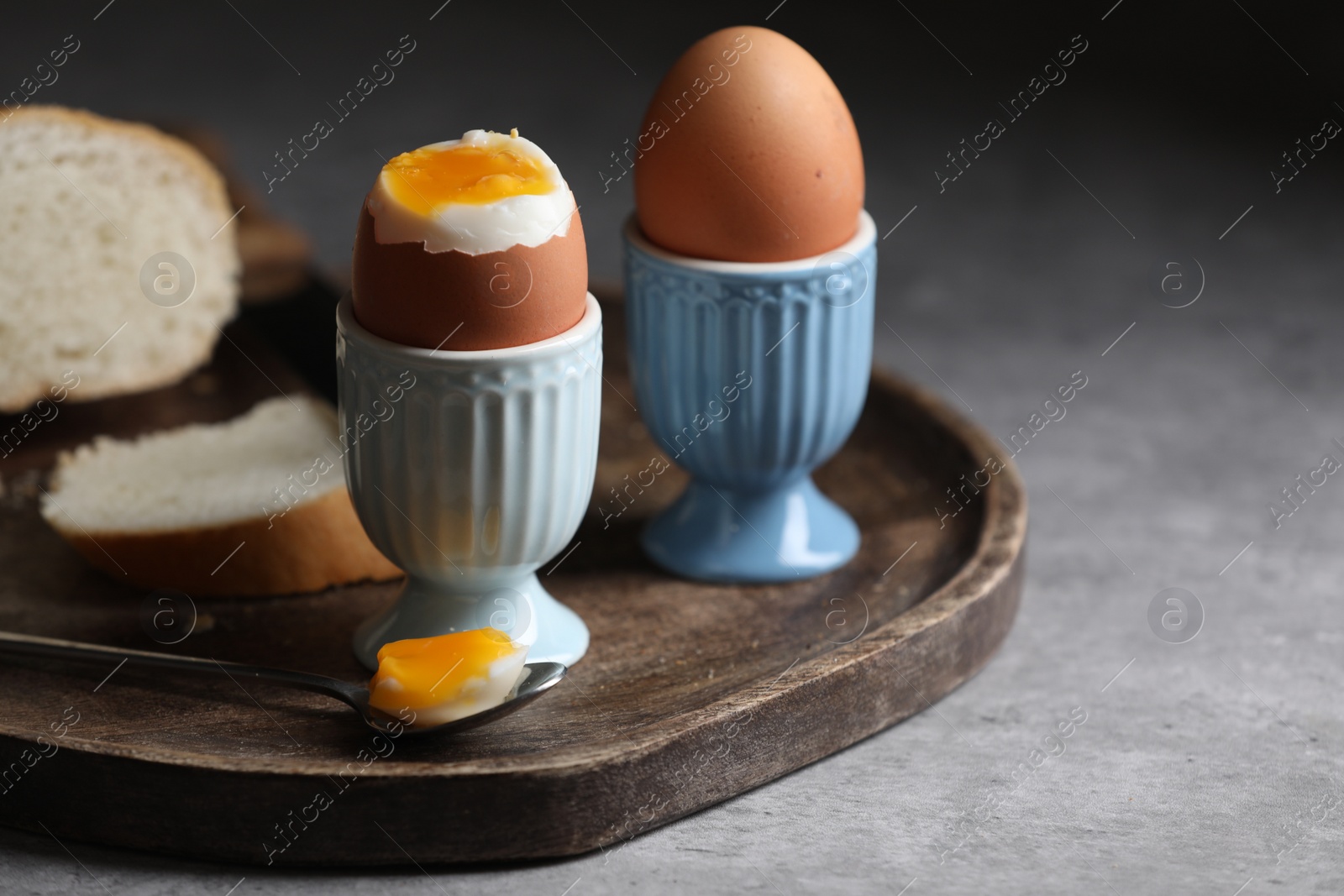 Photo of Tasty boiled chicken eggs with bread on grey table, space for text