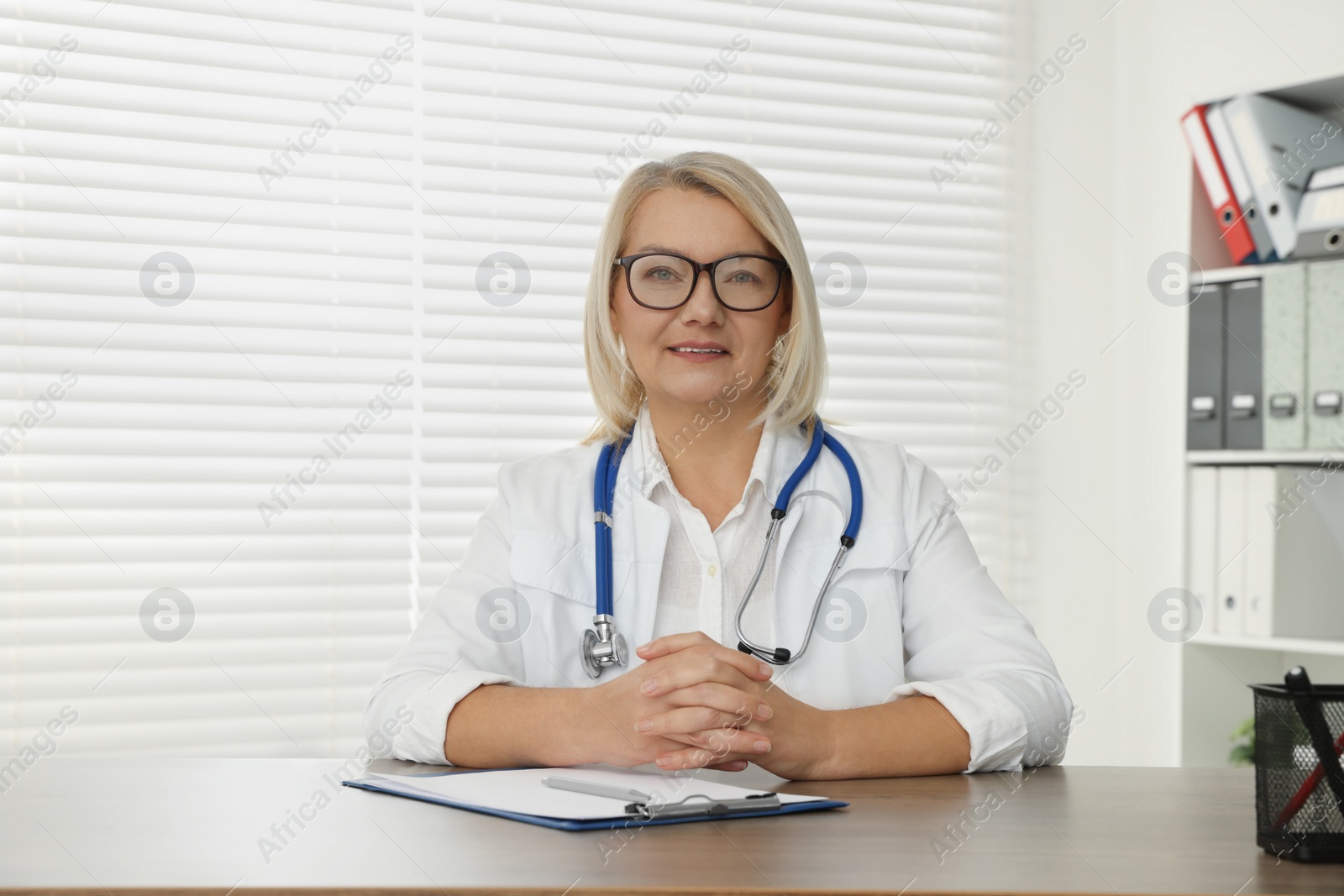 Photo of Doctor sitting at wooden table in clinic