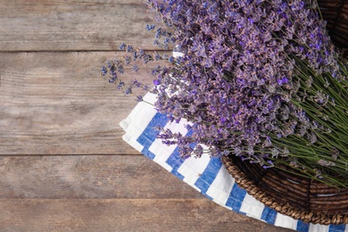 Photo of Bowl with lavender flowers on wooden table, top view