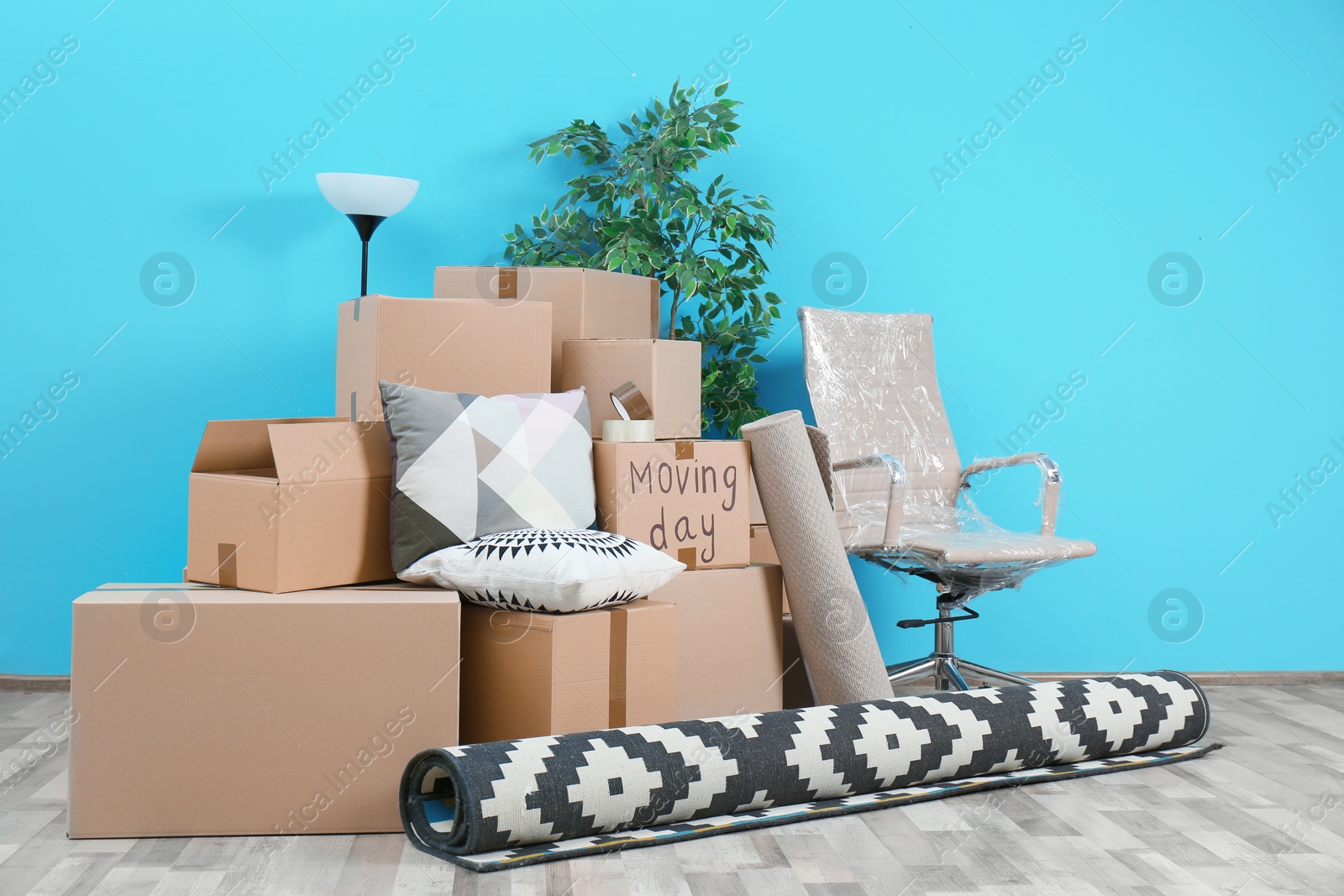 Photo of Cardboard boxes and household stuff in empty room. Moving day