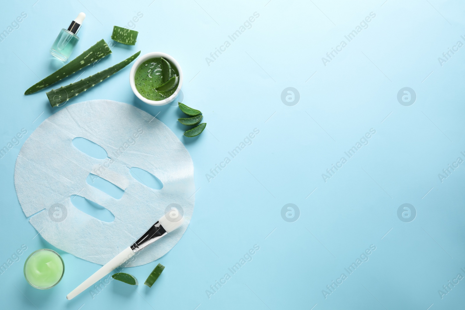 Photo of Flat lay composition with different cosmetic products and aloe on light blue background, space for text