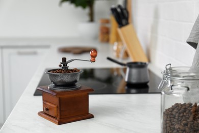 Vintage coffee grinder and beans on countertop in kitchen